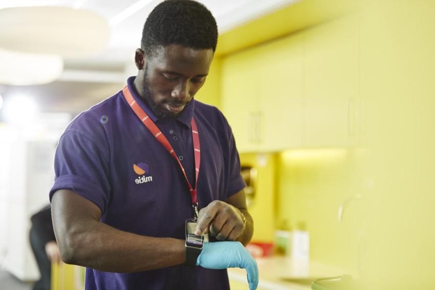Mitie cleaning employee tapping his smart watch